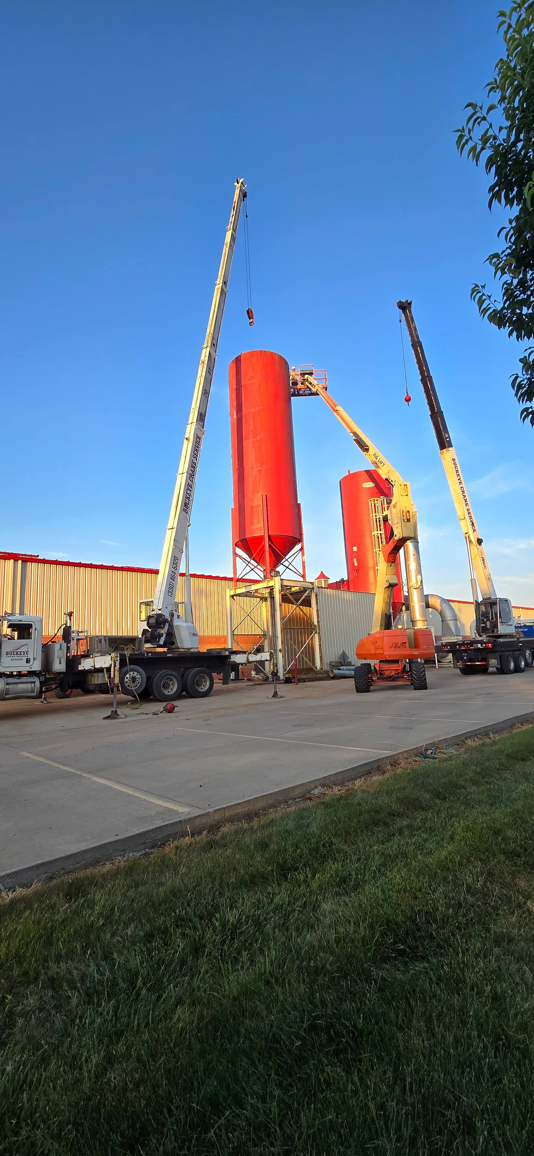 Two Buckeye cranes working together to lift a large industrial tank